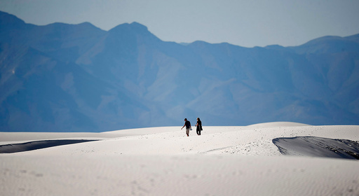 FILE - In this March 5, 2020 photo, hikers head across a dune in White Sands National Park at Holloman Air Force Base, N.M. (AP Photo/David Zalubowski, file) FILE - In this March 5, 2020 photo, hikers head across a dune in White Sands National Park at Holloman Air Force Base, N.M. (AP Photo/David Zalubowski, file)