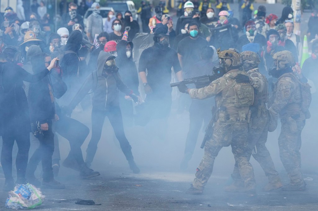 FILE - U.S. Customs and Border Protection agents standoff against demonstrators as tear gas fills the air outside the U.S. Immigration and Customs building during a protest, June 14, 2025, in Portland, Ore. (AP Photo/Jenny Kane, File)