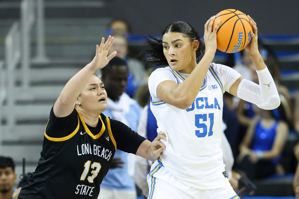 FILE - UCLA center Lauren Betts (51) works the ball inside as Long Beach State guard Khylee Pepe (13) defends during the first half of an NCAA college basketball game, Saturday, Dec. 20, 2025, in Los Angeles. (AP Photo/Jessie Alcheh, File)
