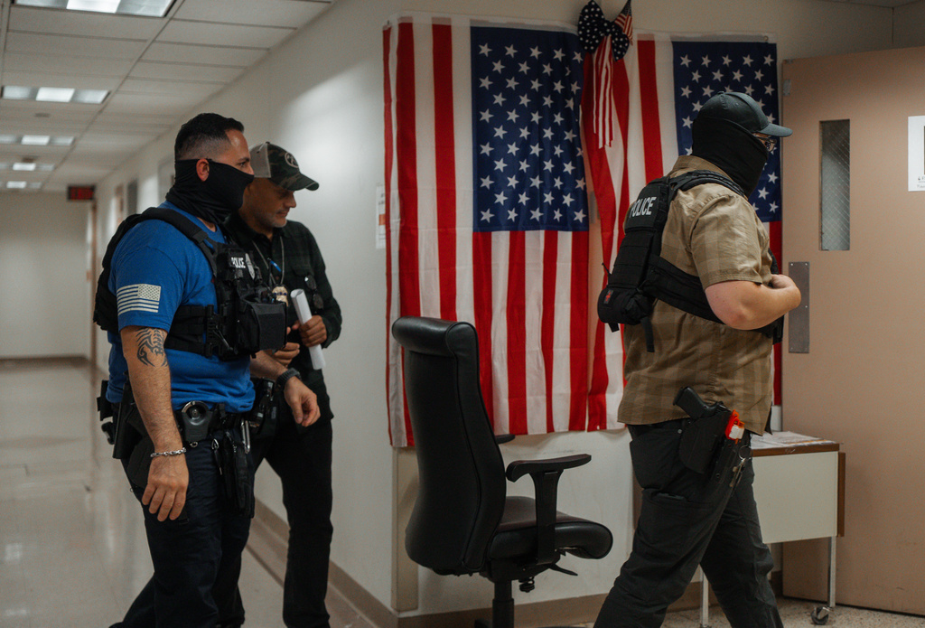 Immigration and Customs Enforcement agents walk through the hallways of the Ted Weiss Federal Building as they wait to detain respondents in immigration court, Thursday, Sept. 4, 2025, in New York. (AP Photo/Olga Fedorova)