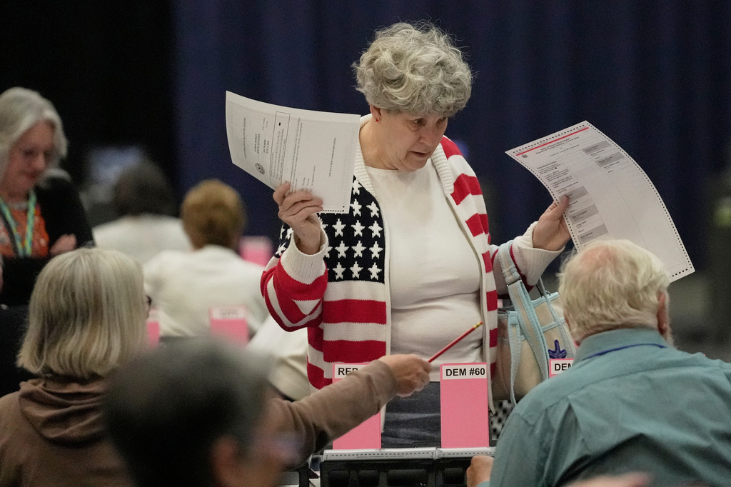 Mary Saunders gets help from election officials after picking up her ballots to vote in the Maine Primary, Tuesday, June 9, 2026, in Augusta, Maine. (AP Photo/Robert F. Bukaty)