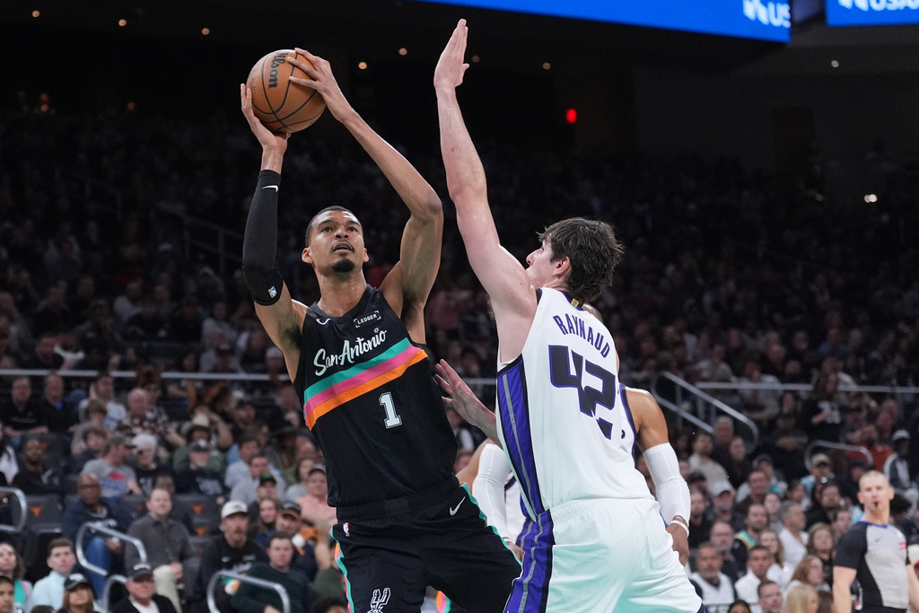 San Antonio Spurs forward Victor Wembanyama (1) shoots past Sacramento Kings center Maxime Raynaud (42) during the second half of an NBA basketball game in Austin, Texas, Saturday, Feb. 21, 2026. (AP Photo/Eric Gay)