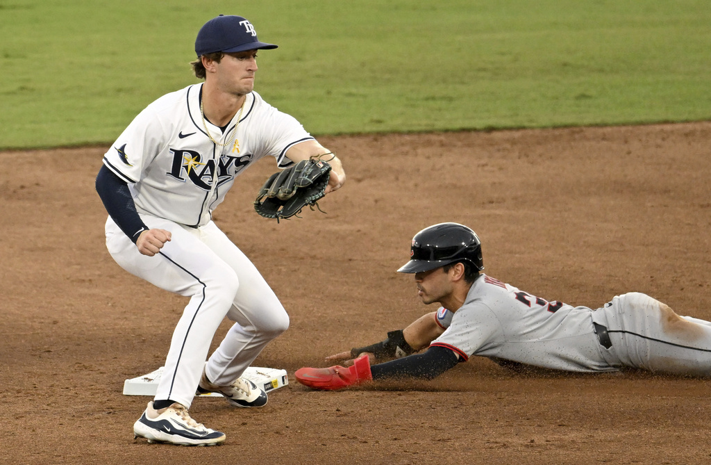 Cleveland Guardians' Steven Kwan, right, steals second base before a tag by Tampa Bay Rays shortstop Carson Williams, left, during the third inning of a baseball game Sunday, Sept. 7, 2025, in Tampa, Fla. (AP Photo/Jason Behnken)