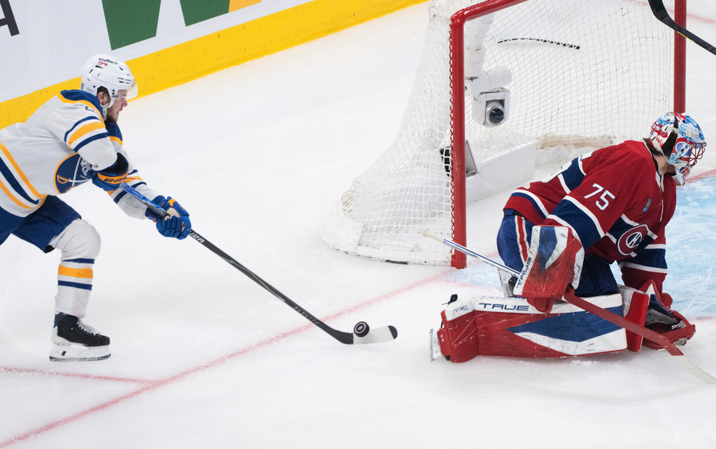 Buffalo Sabres' Zach Benson, left, scores against Montreal Canadiens goaltender Jakub Dobes (75) during the second period of Game 6 in a second-round NHL hockey Stanley Cup playoff series in Montreal, Saturday, May 16, 2026. (Christinne Muschi/The Canadian Press via AP)