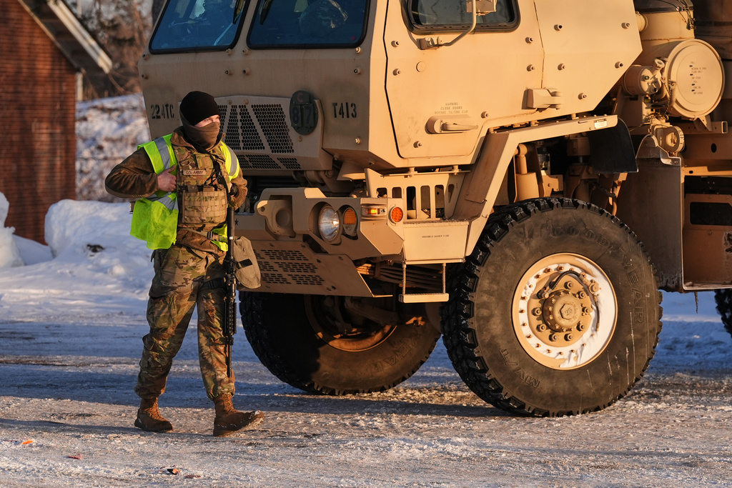 A Minnesota National Guard member walks around with their weapon in front of the Bishop Henry Whipple Federal Building, Sunday, Jan. 25, 2026, in Minneapolis. (AP Photo/Adam Gray)