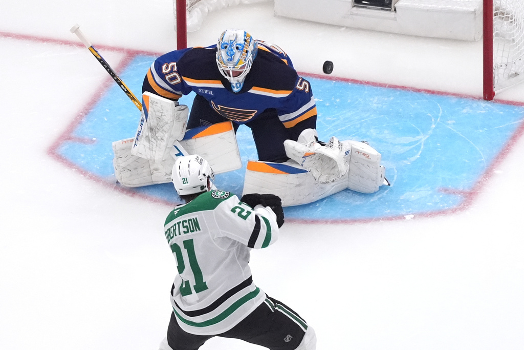 Dallas Stars' Jason Robertson (21) shoots wide of St. Louis Blues goaltender Jordan Binnington (50) during the second period of an NHL hockey game Saturday, Oct. 18, 2025, in St. Louis. (AP Photo/Jeff Roberson)