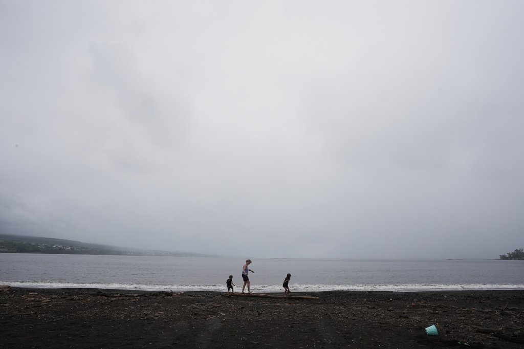 Sheila, of Hilo, Hawaii, plays with her grandchildren as clouds from nearby Hurricane Nolo blanket the skies Friday, Sept. 25, 2026, in Hilo, Hawaii. (AP Photo/Gregory Bull)