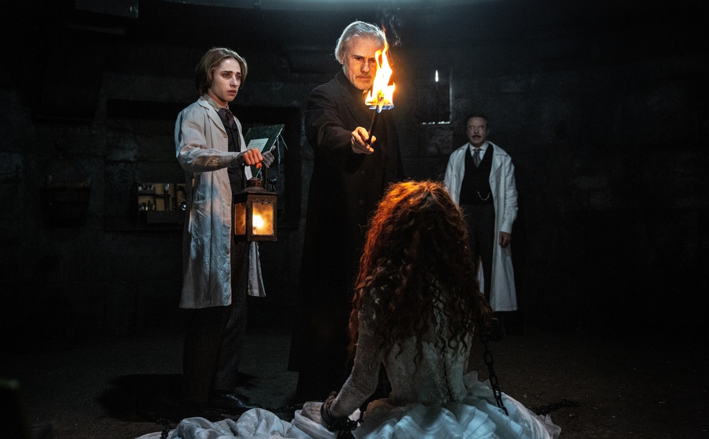 This image released by Vertical Entertainment shows Christoph Waltz, background center, in a scene from "Dracula." (Vertical Entertainment via AP)