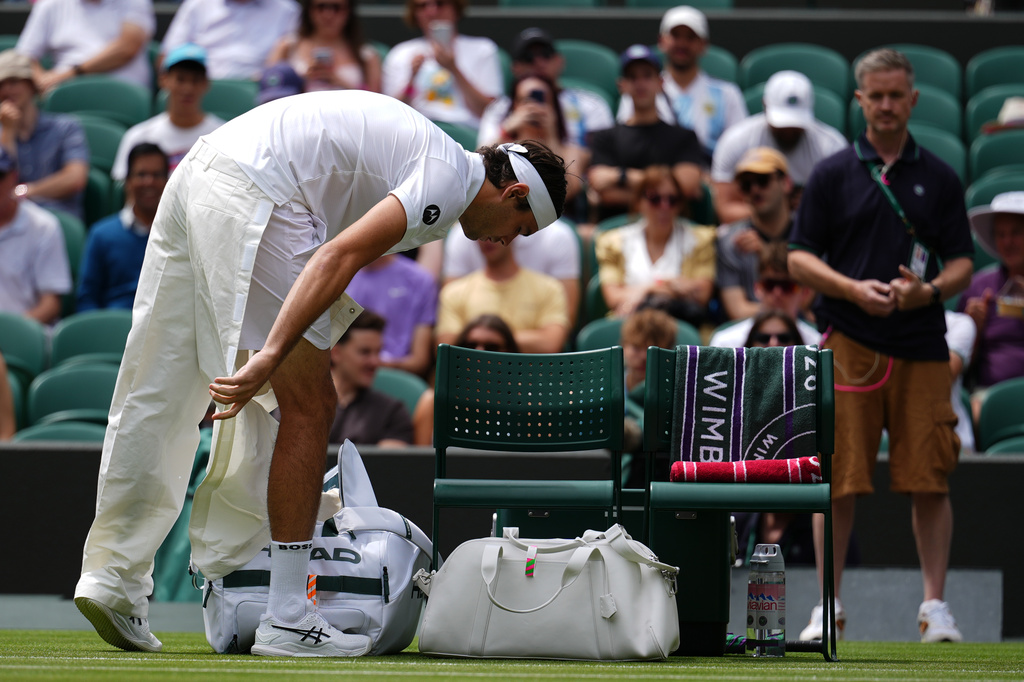Taylor Fritz of the United States takes off his quick-release trousers as he arrives on court 1 to play against Dusan Lajovic of Serbia in their first round men's singles match at the Wimbledon Tennis Championships in London, Tuesday, June 30, 2026. (AP Photo/Kirsty Wigglesworth)