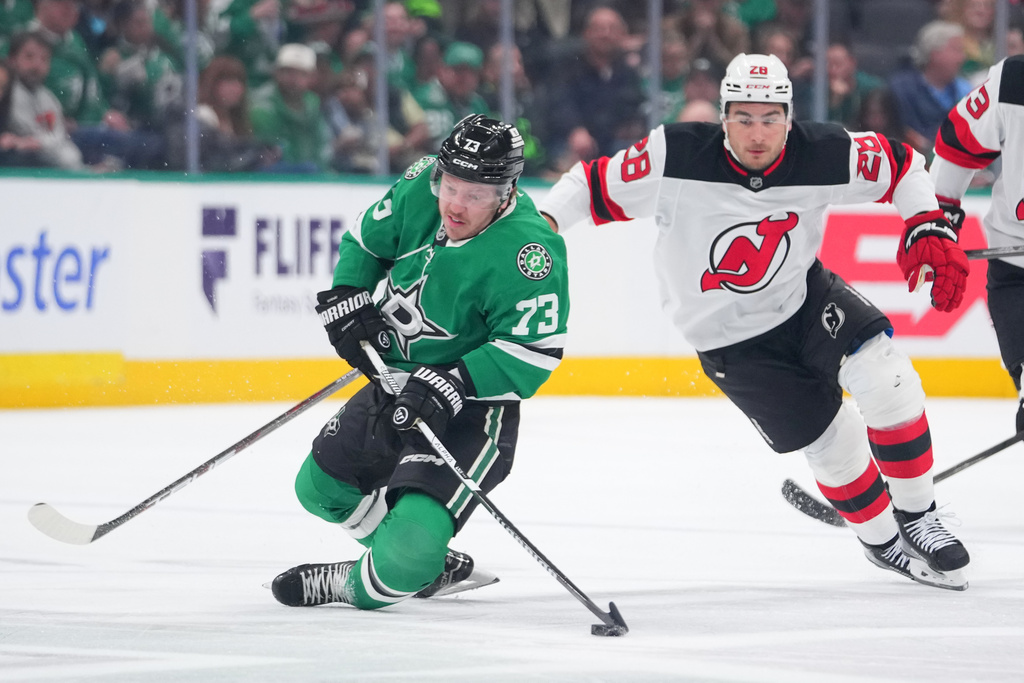 Dallas Stars left wing Adam Erne (73) is tripped up by New Jersey Devils right wing Timo Meier (28) during the first period of an NHL hockey game Tuesday, March 24, 2026, in Dallas. (AP Photo/Julio Cortez)