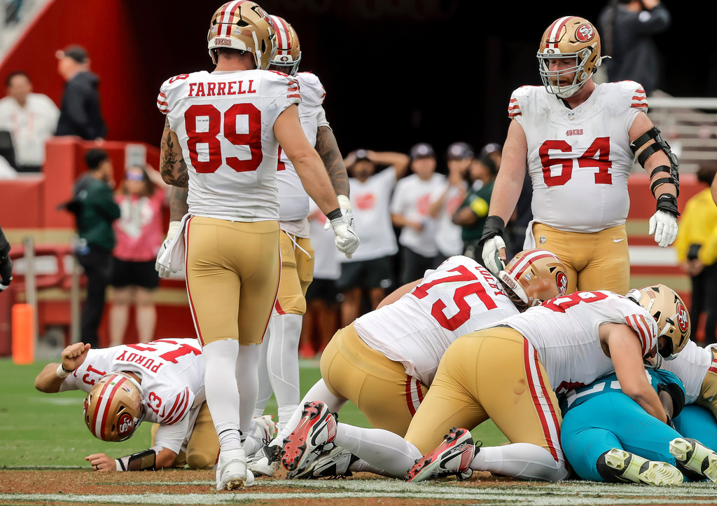 San Francisco 49ers' Brock Purdy (13), lower left, pounds his fist into the turf after his fumble in the final minutes of an NFL football game was recovered by the Jacksonville Jaguars in Santa Clara, Calif., Sunday, Sept. 28, 2025. (Carlos Avila Gonzalez/San Francisco Chronicle via AP)