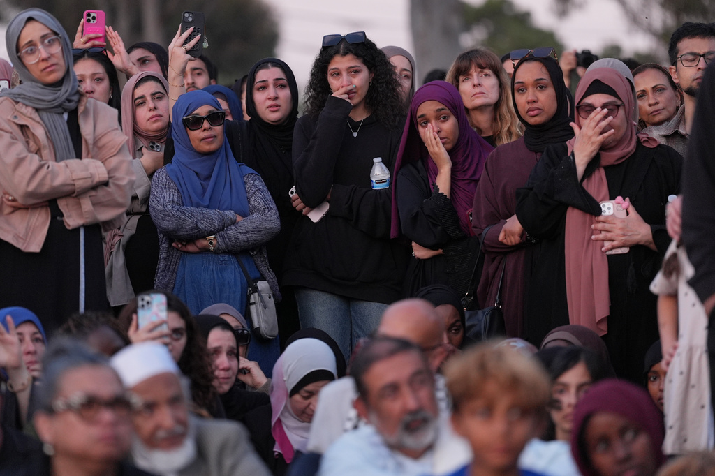 Attendees react as they listen to a speech during a vigil, the day after a shooting, outside of the Islamic Center of San Diego, Tuesday, May 19, 2026, in San Diego. (AP Photo/Jae C. Hong)