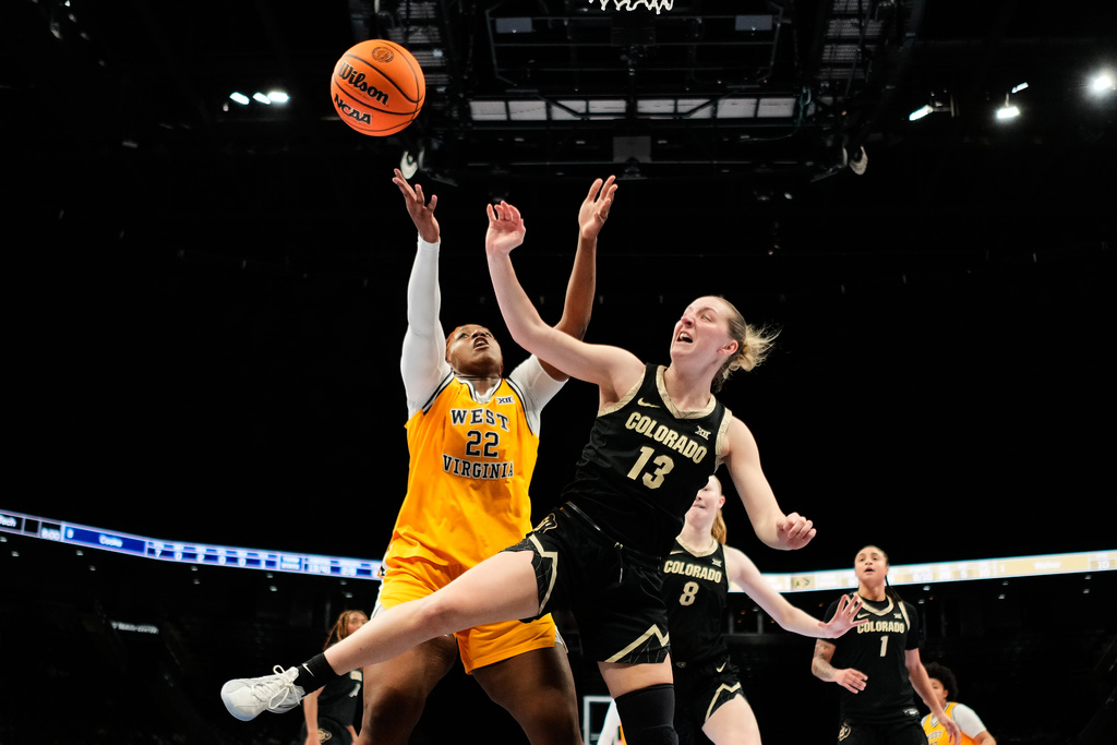 West Virginia's Kierra Wheeler (22) and Colorado's Maeve McErlane (13) chase a rebound during second half of an NCAA college basketball game in the semifinals of the Big 12 Conference tournament Saturday, March 7, 2026, in Kansas City, Mo. (AP Photo/Charlie Riedel)
