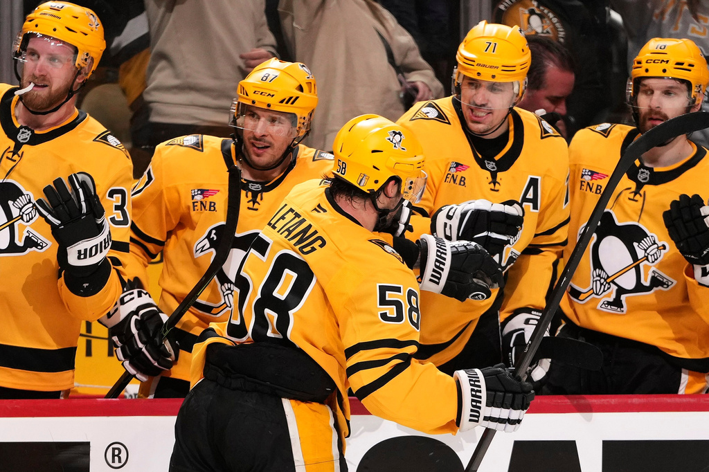 Pittsburgh Penguins' Kris Letang (58) returns to the bench and greetings from Anthony Mantha (39), Sidney Crosby, Evgeni Malkin (71) and Tommy Novak after scoring during the second period of Game 5 in the first round of an NHL hockey Stanley Cup playoff series against the Philadelphia Flyers in Pittsburgh, Monday, April 27, 2026. (AP Photo/Gene J. Puskar)
