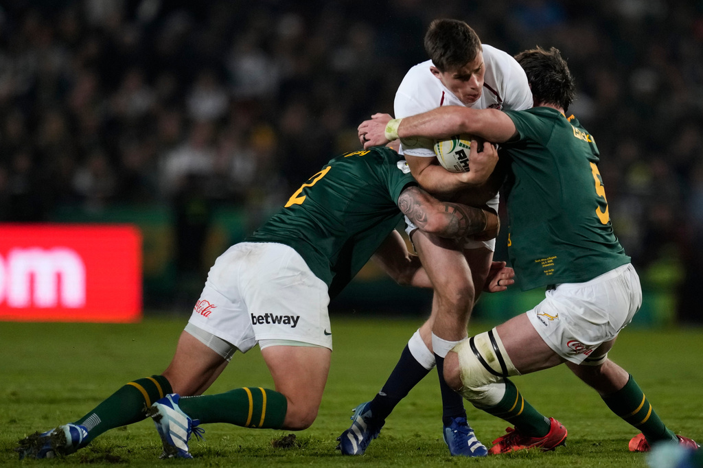 England's Seb Atkinson, is tackled by South Africa's Damian de Allende, left, and his teammate Ruan Nortje during the Nations Championship Test rugby match between South Africa and England, in Johannesburg, South Africa, Saturday, July 4, 2026. (AP Photo/Themba Hadebe)