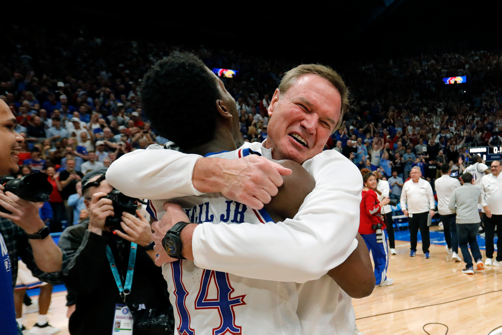 Kansas guard Melvin Council Jr. (14) is hugged by Kansas head coach Bill Self, right, as they celebrate after their team's upset over Arizona in an NCAA college basketball game, Monday, Feb. 9, 2026, in Lawrence, Kan. (AP Photo/Colin E. Braley)