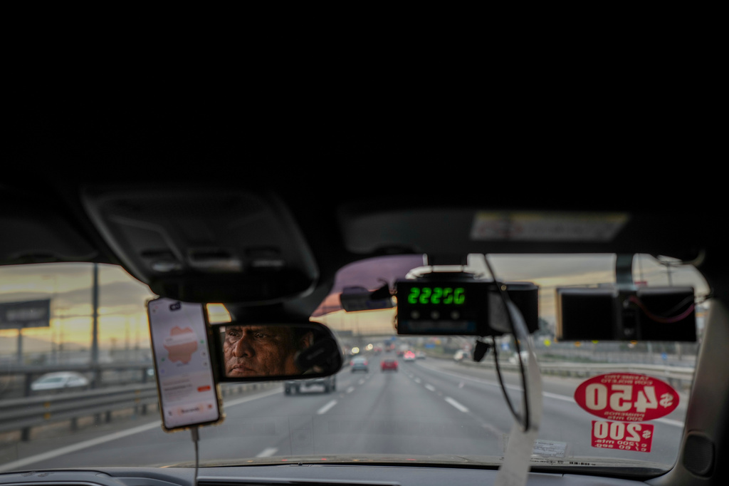 Taxi driver Felipe Molina drives along a street in Santiago, Chile, on Friday, July 10, 2026. (AP Photo/Esteban Felix)