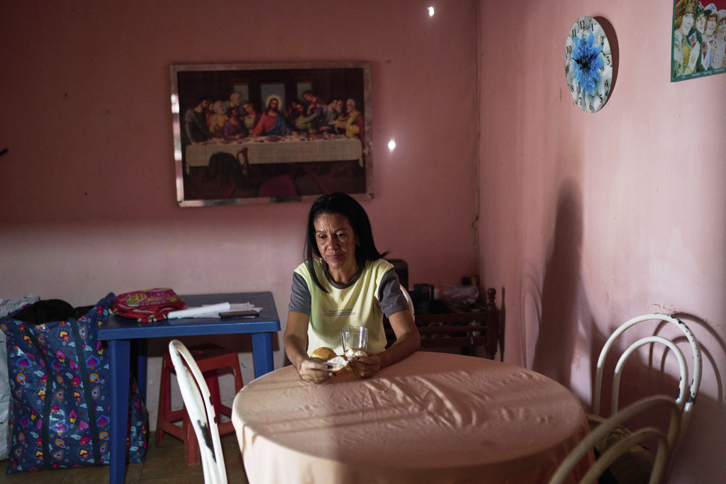 Alnilys Chirino eats bread for breakfast at her home in Coro, Venezuela, Friday, June 27, 2025. (AP Photo/Ariana Cubillos)