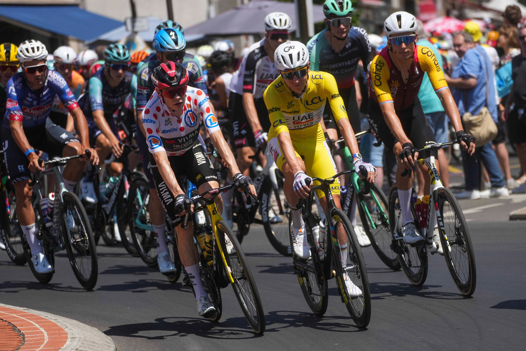 Slovenia's Tadej Pogacar, center, wearing the overall leader's yellow jersey, rides in the pack during the tenth stage of the Tour de France cycling race with start in Aurillac and finish in Le Lioran, during the Tour de France Cycling race in France, Tuesday, July 14, 2026. (AP Photo/Thibault Camus)