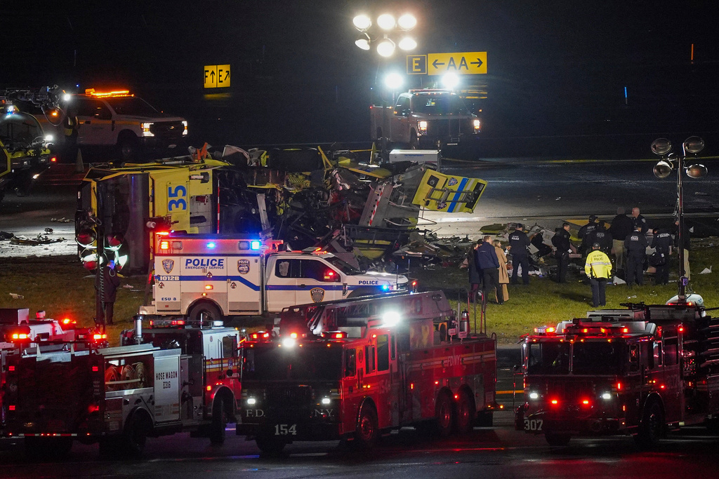 A Port Authority aircraft rescue and firefighting vehicle lays on its side off of runway 4 after colliding with an Air Canada jet after it landed at LaGuardia Airport, Monday, March 23, 2026, in New York. (AP Photo/Ryan Murphy)