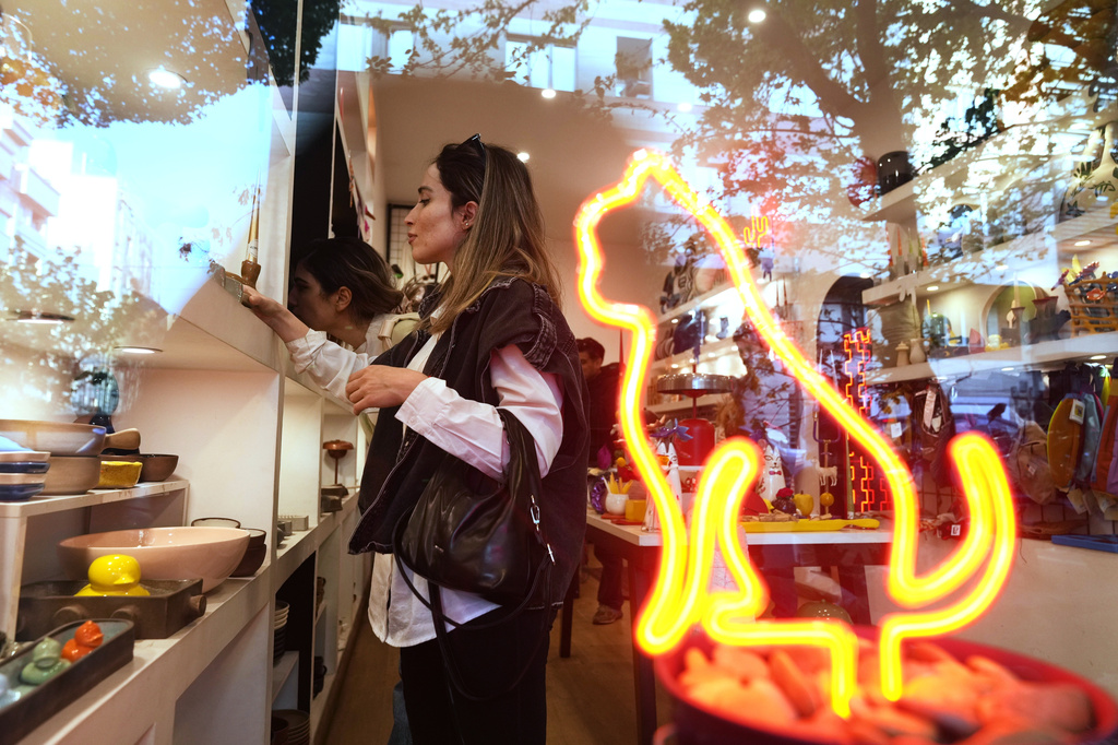 Customers browse inside a gift shop in central Tehran, Iran, Wednesday, April 8, 2026. (AP Photo/Francisco Seco)