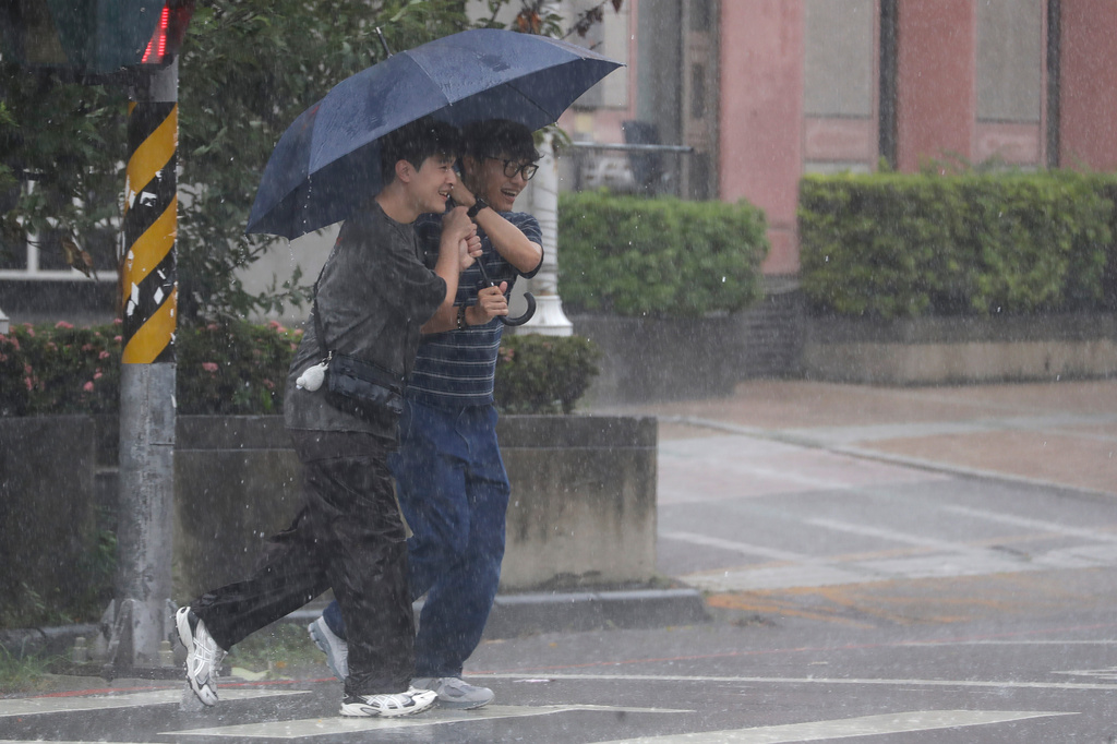 People make their way in a rain caused by Typhoon Bavi in Taichung, Taiwan, Saturday, July 11, 2026. (AP Photo/Chiang Ying-ying)