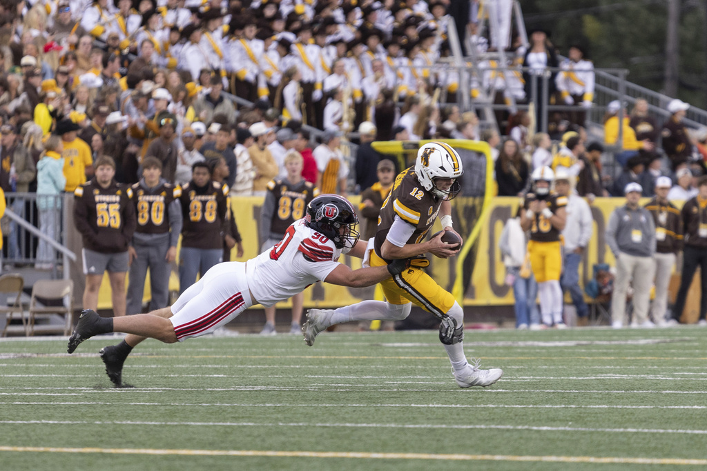 Utah defensive end John Henry Daley, left, sacks Wyoming quarterback Kaden Anderson, right, during the first half of an NCAA college football game Saturday, Sept. 13, 2025, in Laramie, Wyo. (AP Photo/Matthew Idler)