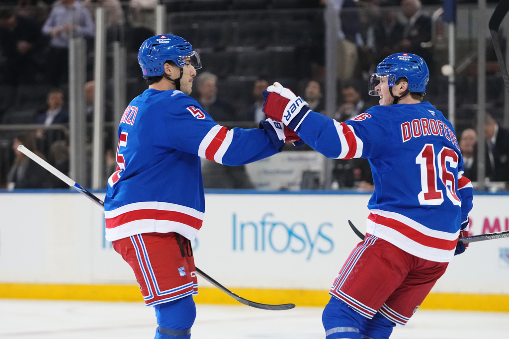 New York Rangers' Sean Durzi (5) celebrates with teammate Pavel Dorofeyev (16) after scoring a goal during the first period of an NHL hockey game against the Anaheim Ducks Monday, Oct. 19, 2026, in New York. (AP Photo/Frank Franklin II)