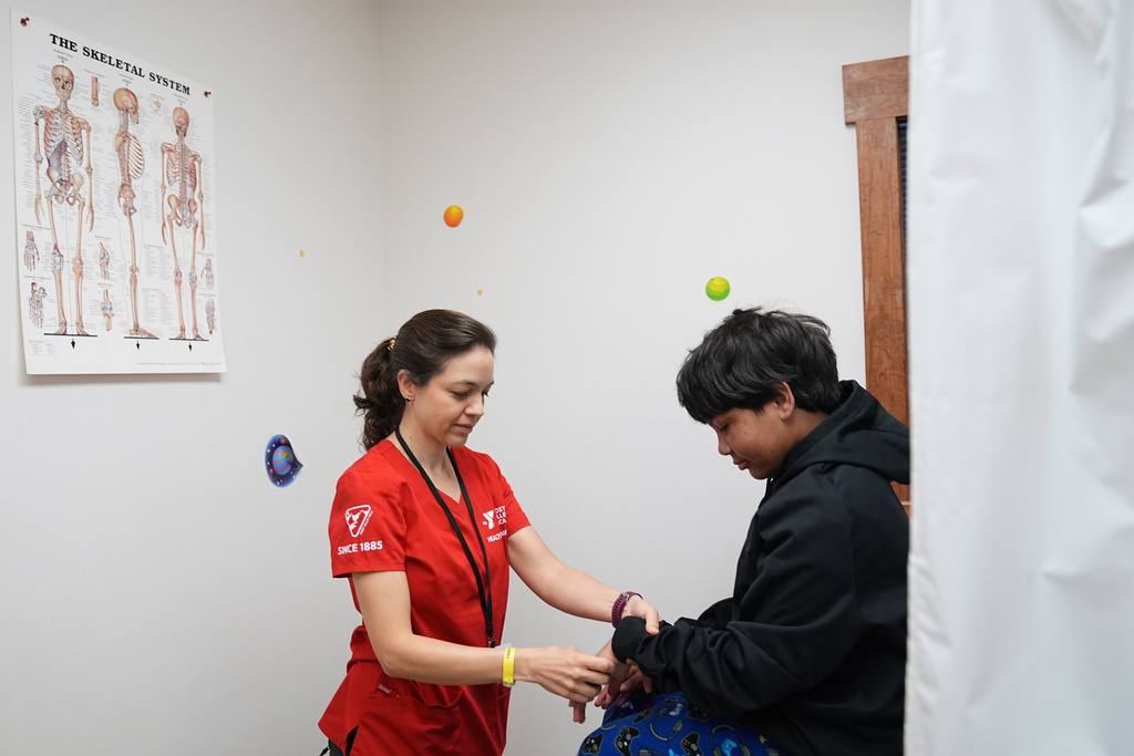 Dr. Natalia Vasquez-Canizares, left, examines camper Dylan Aristy Mota, 12, of New York City, who has lupus, at the Frost Valley YMCA sleepaway camp in Claryville, N.Y., Thursday, July 31, 2025. The camp partnered with Children's Hospital at Montefiore so kids with autoimmune diseases could attend for the first time. (AP Photo/Matt Rourke)