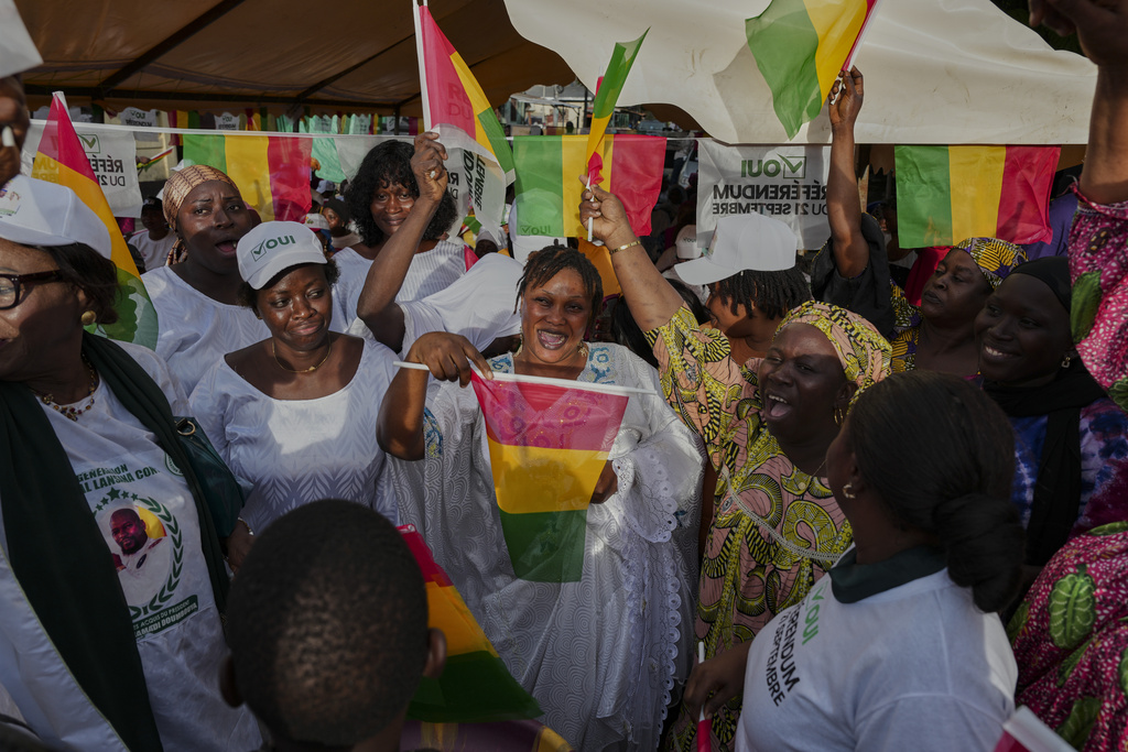 Supporters cheer and wave Guinean flags during a community rally ahead of the constitutional referendum in Conakry, Guinea, Monday, Sept. 15, 2025. (AP Photo/Misper Apawu)