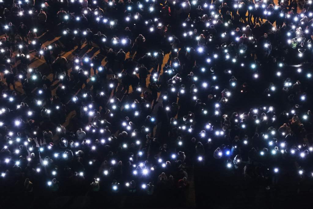 People turn the lights on on their mobile phones as they join the protest on the first anniversary of the disaster that killed 16 people, in Novi Sad, Serbia, Saturday, Nov. 1, 2025. (AP Photo/Armin Durgut)