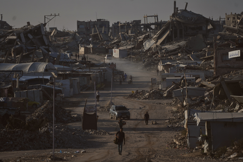 Palestinians walk along a road surrounded by buildings destroyed in Israeli military strikes during the Israel-Hamas war, in Jabaliya, Gaza Strip, Thursday, July 2, 2026. (AP Photo/Jehad Alshrafi)