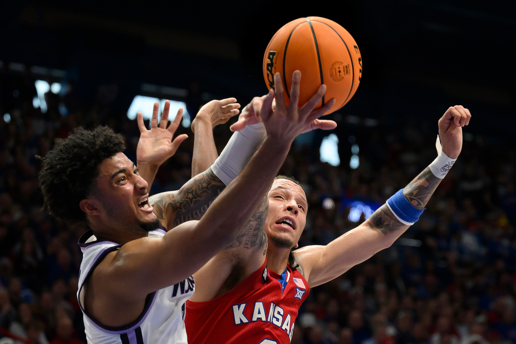 Kansas State guard PJ Haggerty, left, battles Kansas guard Tre White, right, for a rebound during the first half of an NCAA college basketball game in Lawrence, Kan., Saturday, March 7, 2026. (AP Photo/Reed Hoffmann)