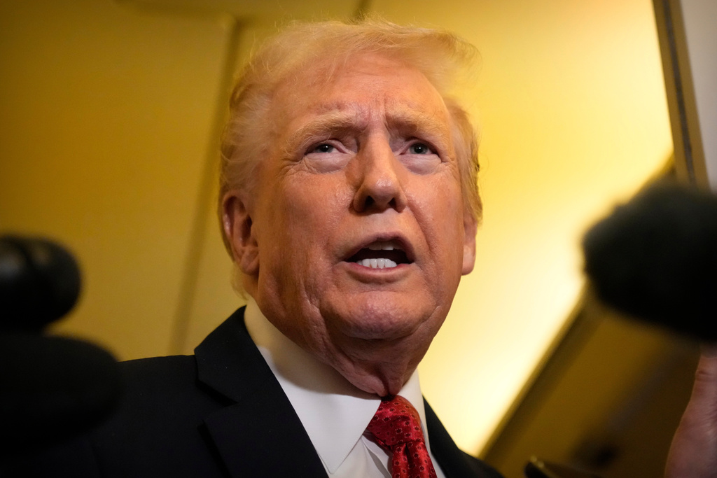 President Donald Trump speaks to reporters aboard Air Force One, Sunday, Oct. 19, 2025, en route to Joint Base Andrews, Md., as he returns from a trip to Florida. (AP Photo/Mark Schiefelbein)