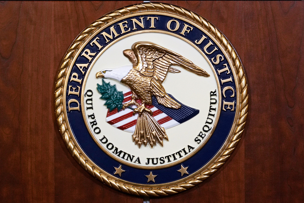 FILE - The seal of the Dept of Justice is shown on the podium, Aug. 1, 2023, at an office of the Department of Justice in Washington. (AP Photo/J. Scott Applewhite, File)