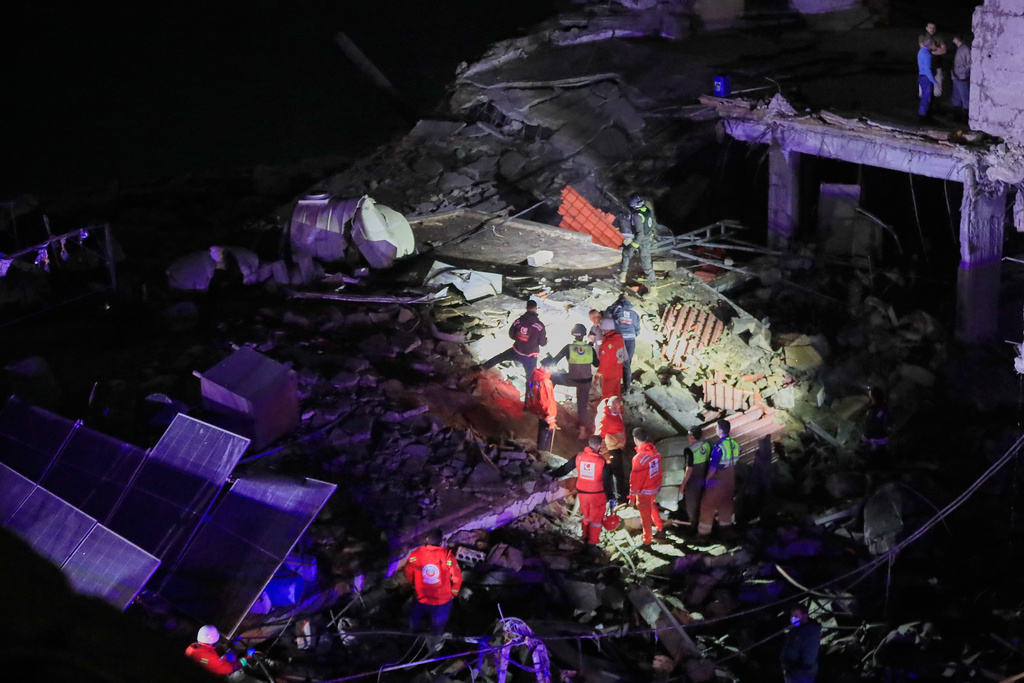Rescue workers search for possible victims in a building destroyed by an Israeli airstrike in the southern port city of Sidon, Lebanon, early Tuesday, Jan. 6, 2026. (AP Photo/Mohammed Zaatari)