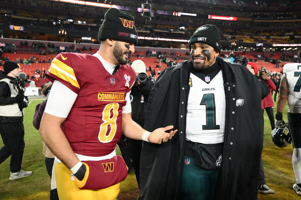 Washington Commanders quarterback Marcus Mariota (8) and Philadelphia Eagles quarterback Jalen Hurts (1) talk after an NFL football game, Thursday, Dec. 20, 2025, in Landover, Md. (AP Photo/Nick Wass)