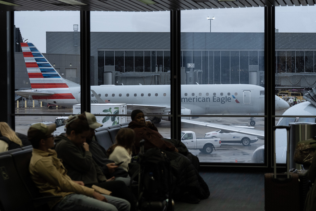 People wait for American Airlines flights at Chicago O'Hare International Airport in Chicago, Ill., Sunday, Nov. 9, 2025. (AP Photo/Adam Gray)