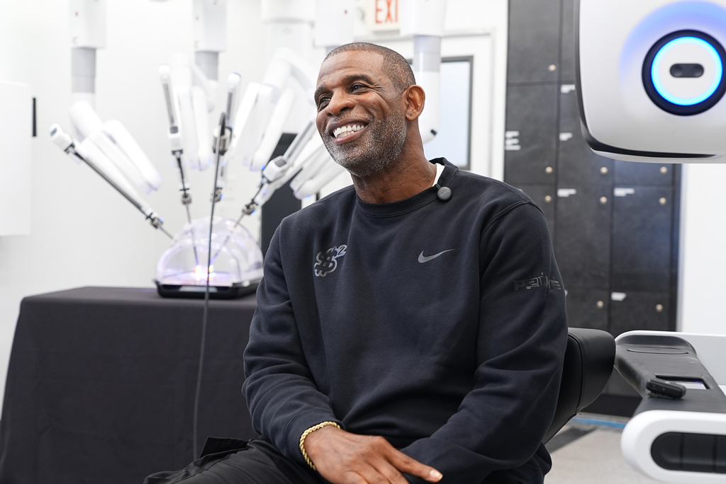 Colorado head football coach Deion Sanders talks about working the Da Vinci robotic surgical machine used to remove his cancerous bladder last year during a demonstration of the device Tuesday, June 23, 2026, in Boulder, Colo. (AP Photo/David Zalubowski)
