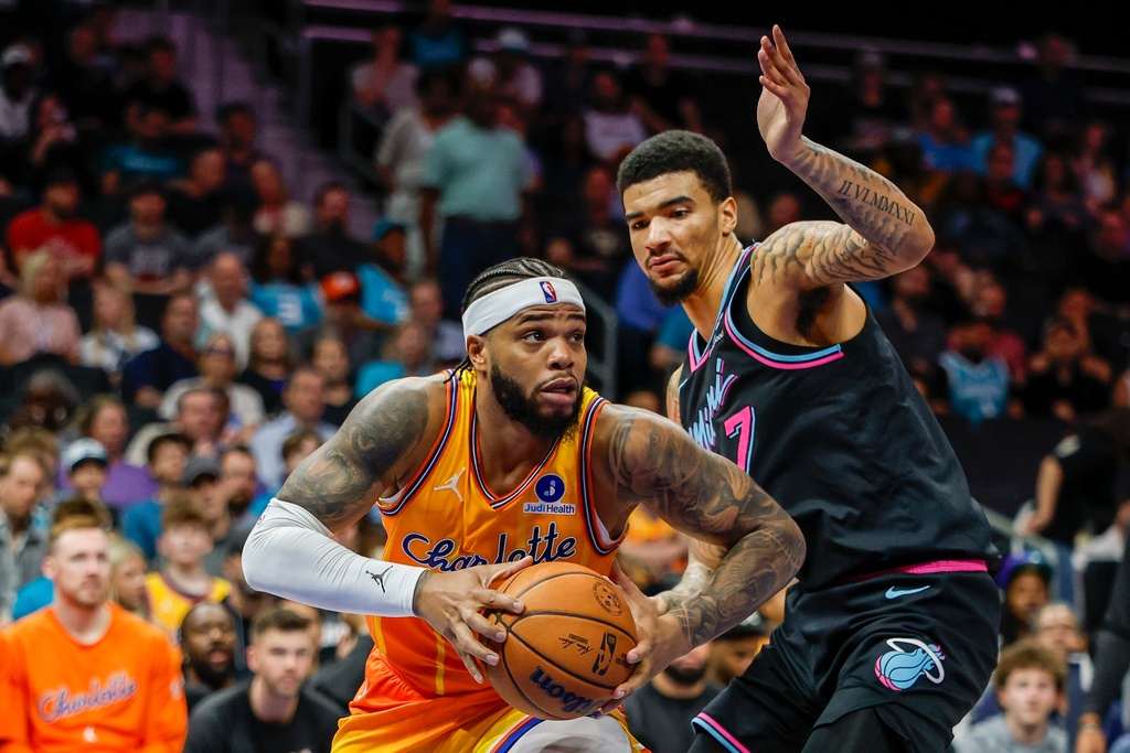 Charlotte Hornets forward Miles Bridges, left, drives against Miami Heat center Kel'el Ware during the first half of an NBA basketball game in Charlotte, N.C., Friday, March 6, 2026. (AP Photo/Nell Redmond)