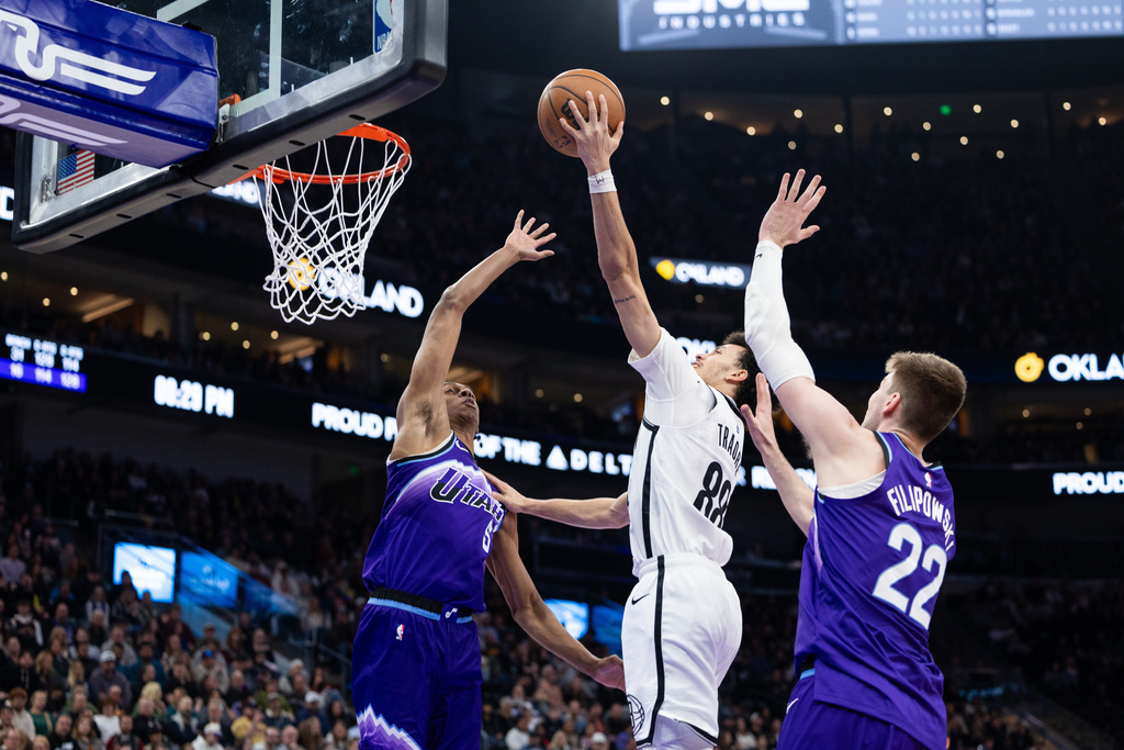 Utah Jazz center Kyle Filipowski (22) and forward Cody Williams (5) defend against Brooklyn Nets guard Nolan Traore (88) who goes up to shoot during the second half of an NBA basketball game, Friday, Jan. 30, 2026, in Salt Lake City. (AP Photo/Anna Fuder)