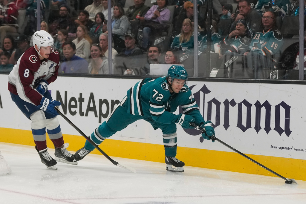 San Jose Sharks left wing William Eklund (72) reaches for the puck in front of Colorado Avalanche defenseman Cale Makar (8) during the first period of an NHL hockey game in San Jose, Calif., Saturday, Nov. 1, 2025. (AP Photo/Jeff Chiu)