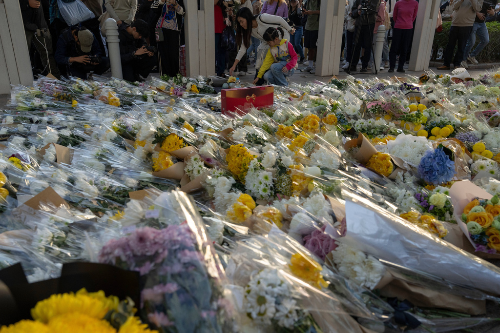 Flowers are placed near the site of the deadly Wednesday fire at Wang Fuk Court, a residential estate in the Tai Po district of Hong Kong's New Territories on Saturday, Nov. 29, 2025. (AP Photo/Ng Han Guan)