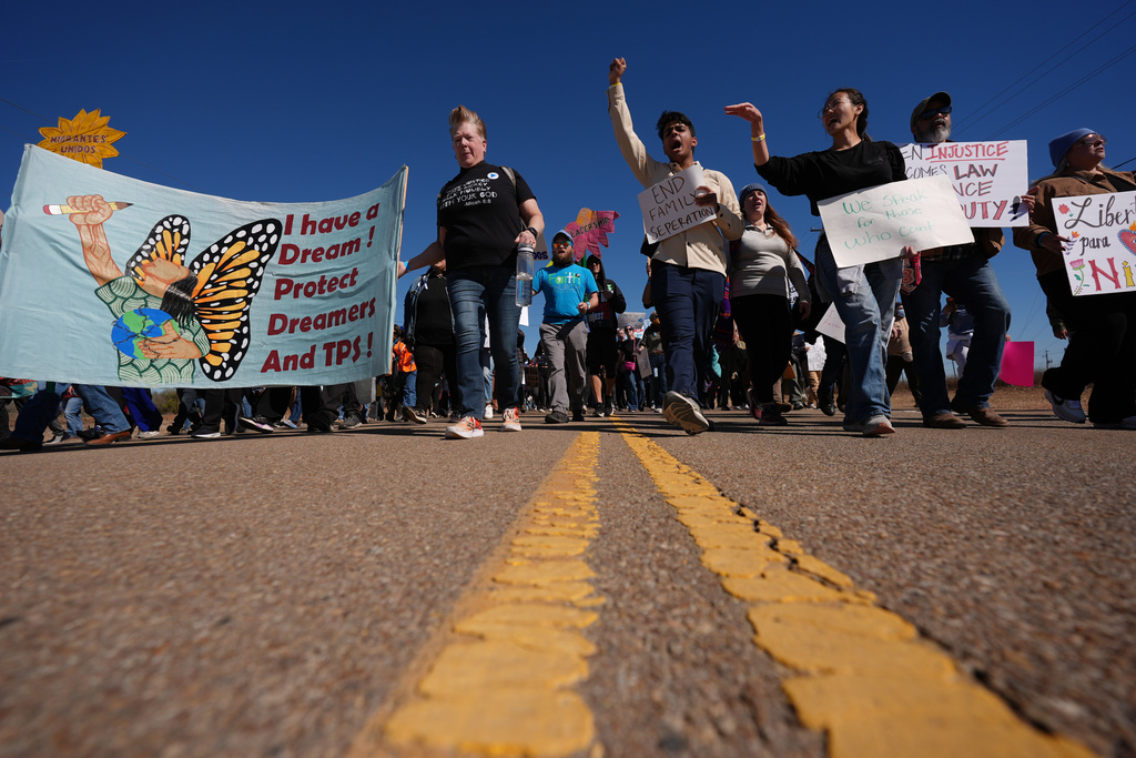 Protesters march to the South Texas Family Residential Center detention facility where Liam Ramos and his father are being detained in Dilley, Texas, Wednesday, Jan. 28, 2026. (AP Photo/Eric Gay)