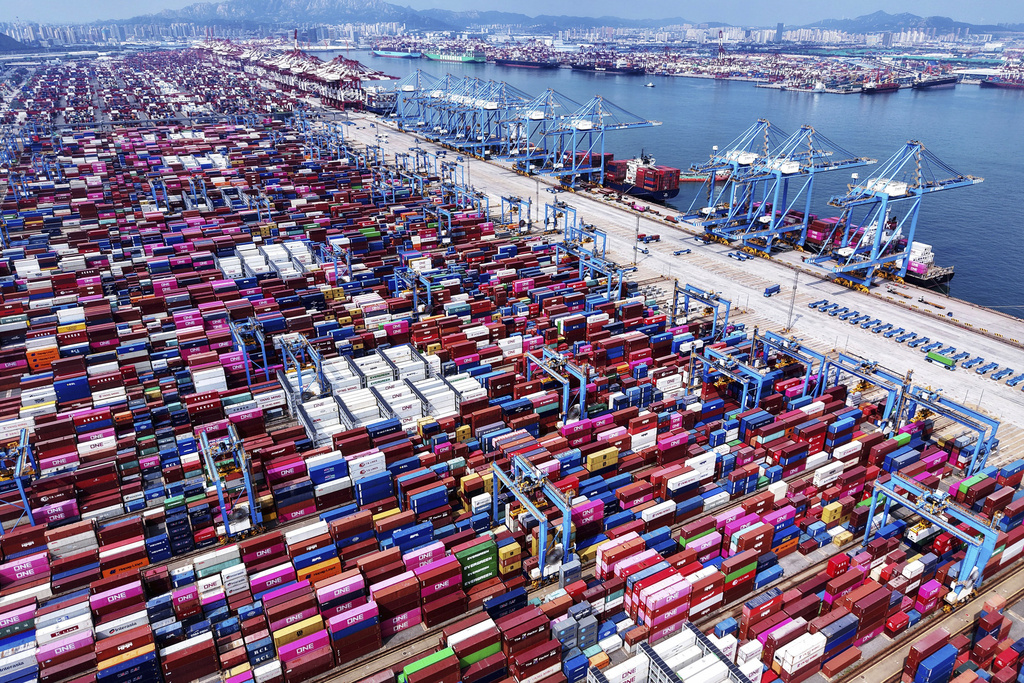 Cranes load containers and unload them from vessels at a container terminal in Qingdao in east China's Shandong province, Monday, Aug. 11, 2025. (Chinatopix Via AP)