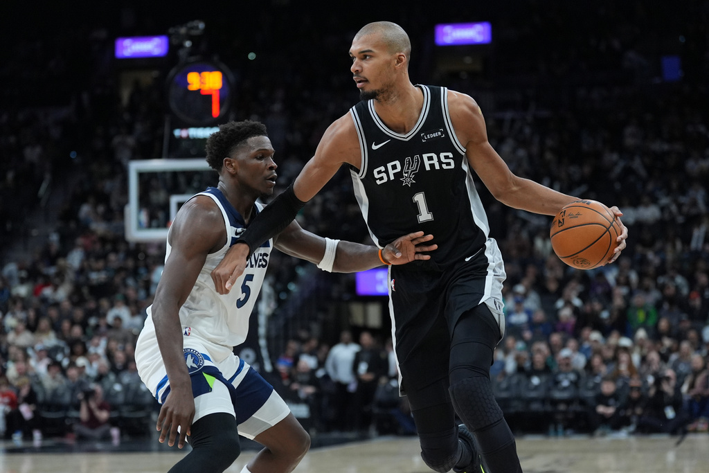 San Antonio Spurs forward Victor Wembanyama (1) drives against Minnesota Timberwolves guard Anthony Edwards (5) during the second half of an NBA basketball game in San Antonio, Saturday, Jan. 17, 2026. (AP Photo/Eric Gay)