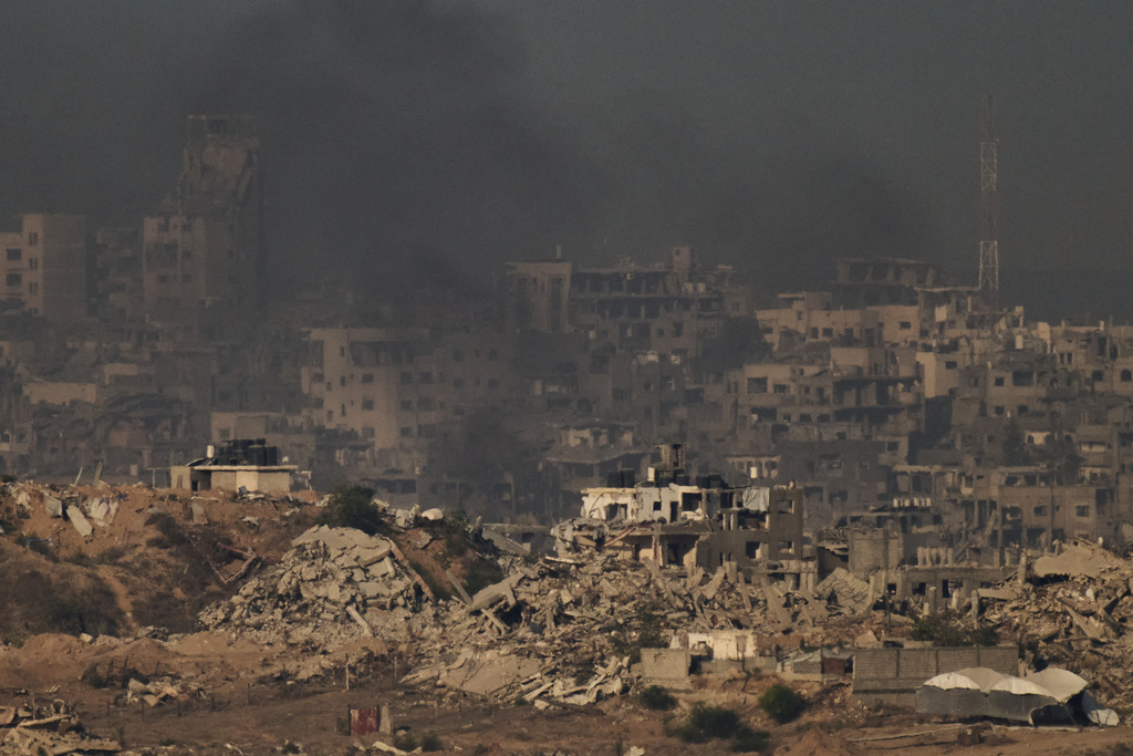 Buildings that were destroyed during the Israeli ground and air operations stand in the northern Gaza Strip during the sunrise, as seen from southern Israel, Friday, Oct. 17, 2025. (AP Photo/Leo Correa)