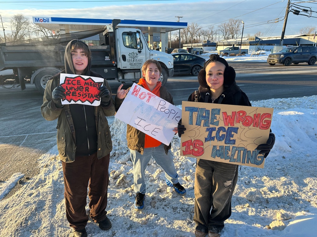 From left, Asher O'Donnel, Ryan Maddox and Amari Perez-Wayner hold signs as several dozen Groves High School students who walked out of morning class on Friday, Jan. 30, 2026 in Birmingham, Mich. (AP Photo/Corey R. Williams)