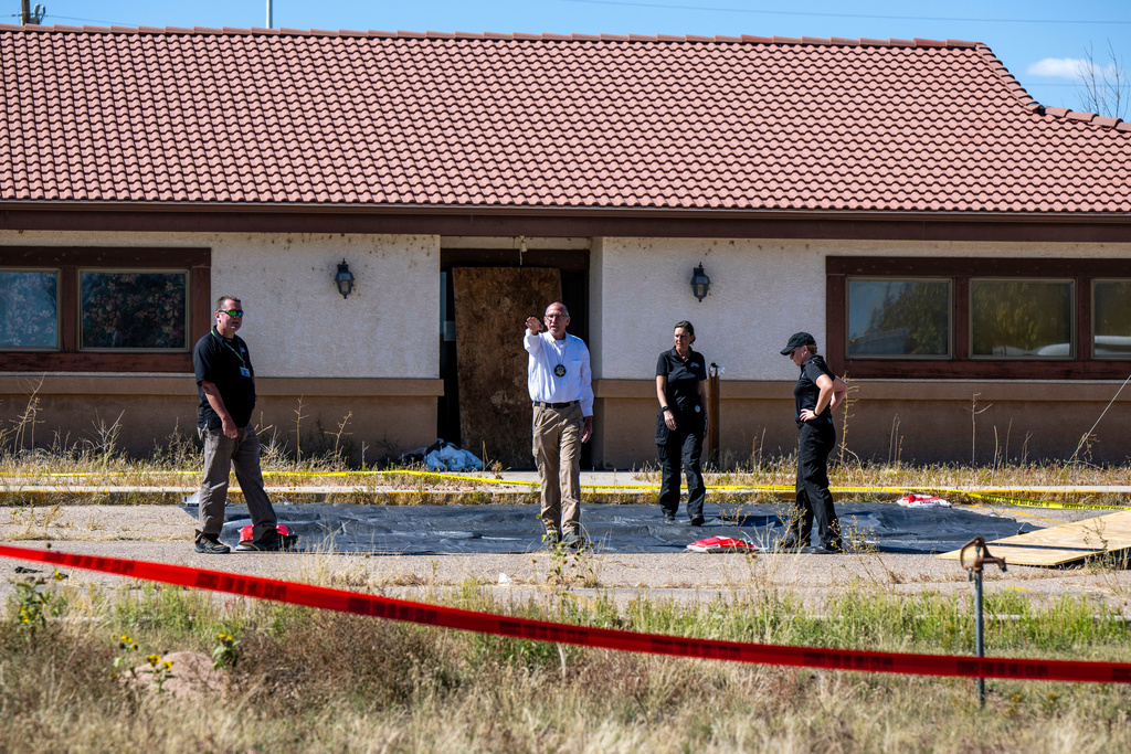 FILE - Fremont County coroner Randy Keller, center, and other authorities survey the area where they plan to put up tents at the Return to Nature Funeral Home where over 100 bodies have been improperly stored, Oct. 7, 2023, in Penrose, Colo. (Parker Seibold/The Gazette via AP, File)