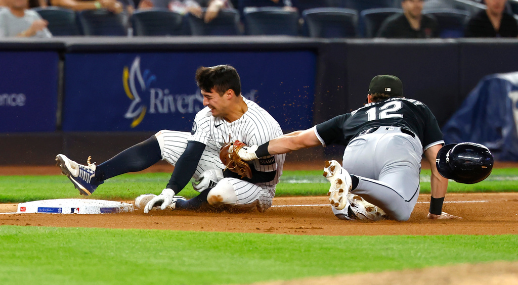 New York Yankees' shortstop Anthony Volpe is tagged out at third base by Chicago White Sox's Colson Montgomery (12) during the seventh inning of a baseball game, Thursday, June 18, 2026, in New York. (AP Photo/Noah K. Murray)